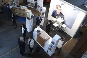 Professioneller Messestand mit Besuchern und Werbebanner