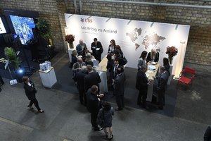 Professioneller Messestand mit Besuchern und Mitarbeitern im Gespräch